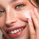 момиче с лунички с крем на бузата